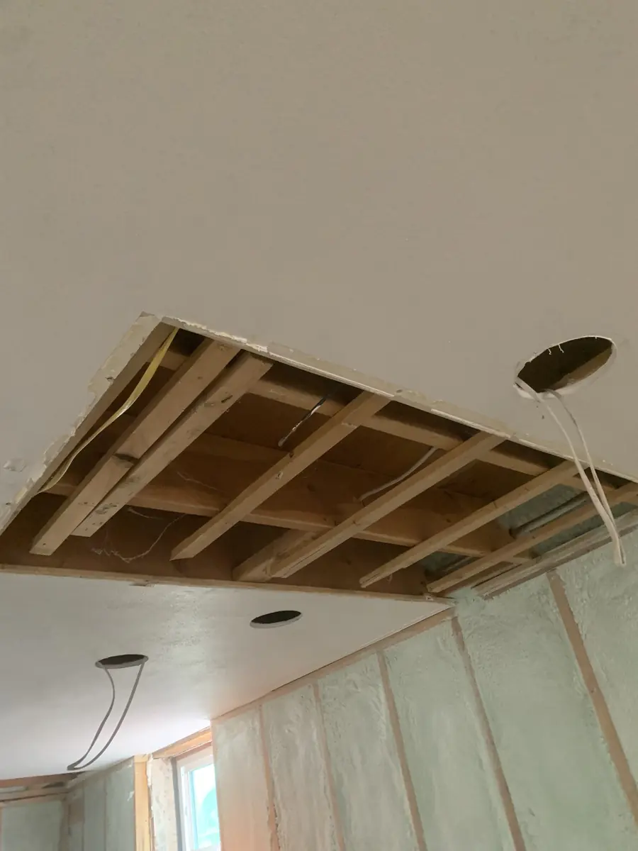 Ceiling opened to the framing during a drywall repair before new board and finish