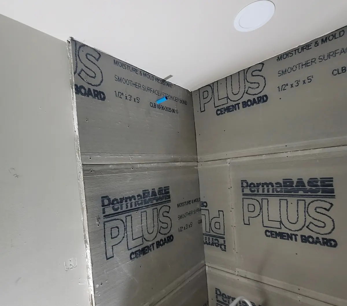 Cement board installed in a shower enclosure during a bathroom remodel