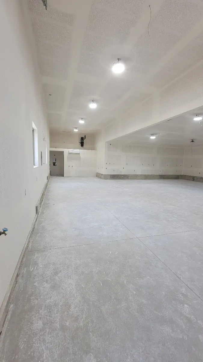 Finished oversized garage with knockdown-textured drywall and recessed lighting