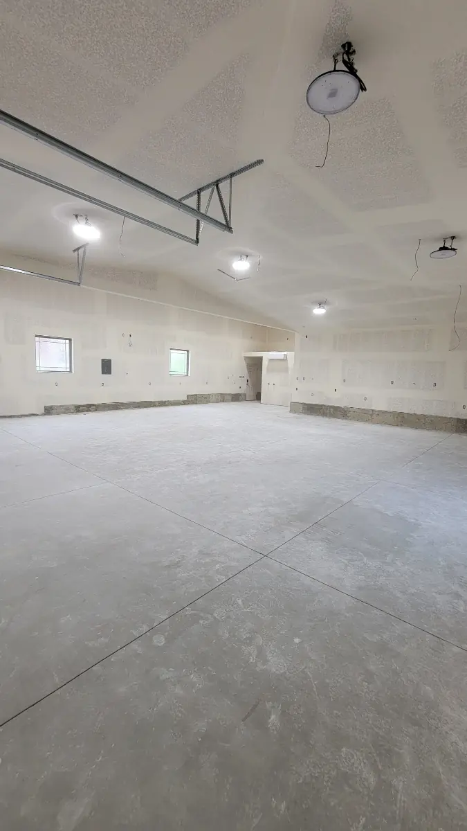 Finished garage drywall with a knockdown-textured ceiling and recessed lights
