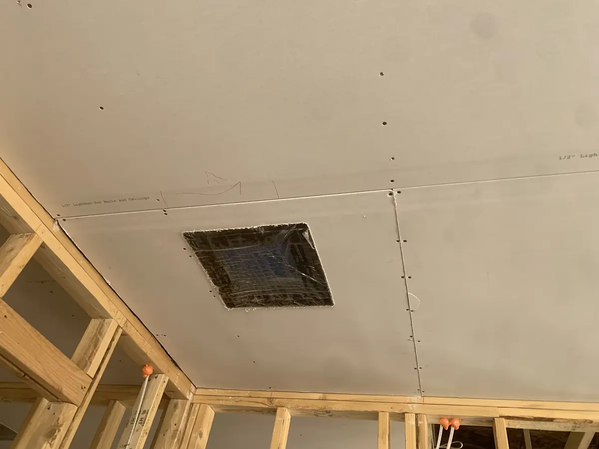 Drywall ceiling hung over framing before taping on a new-construction project
