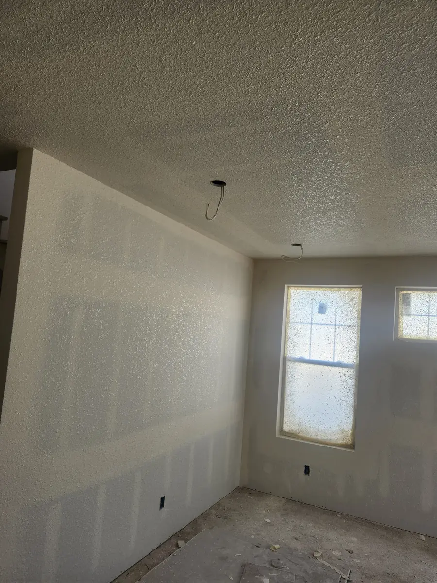 Knockdown-textured drywall ceiling in a room with taped, paint-ready walls