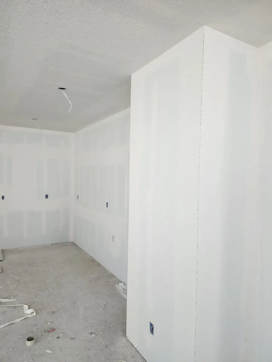 Level 4 drywall finish in a room with a smooth corner column, ready for primer